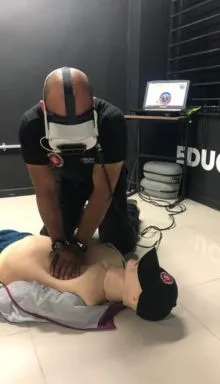 Instructor de Sema SAS realizando capacitación en reanimación cardiopulmonar con simulador y gafas de realidad virtual.